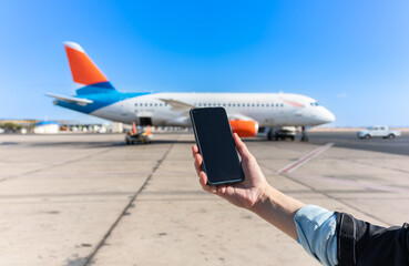 Girl holds a smartphone with a black screen close-up. Phone on the background of the airport with...