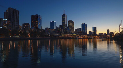 Naklejka premium City skyline at night with skyscrapers reflecting on river under deep blue sky