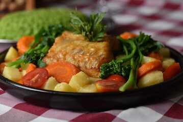 codfish typical Portuguese dish baked cod with onion garlic peppers and potatoes rustic Portuguese food salted fish cooked olive oil