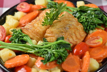 codfish typical Portuguese dish baked cod with onion garlic peppers and potatoes rustic Portuguese food salted fish cooked olive oil