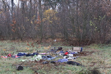 Trash in the forests of Ukraine. Bad irresponsible people pollute nature. Plastic bags, old clothes, trash are scattered across the lawn. Animals are suffering