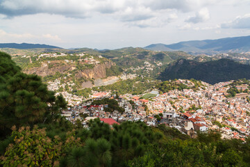 Aerial panoramic view over Pueblo Magico of Taxco, one of Mexico's most scenic towns with Santa Prisca church and a scenic mountainous landscape. Taxco, Guerrero, Mexico