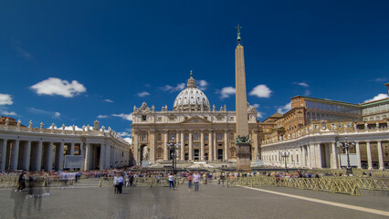 St. Peter's Square full of tourists with St. Peter's Basilica and the Egyptian obelisk within the...