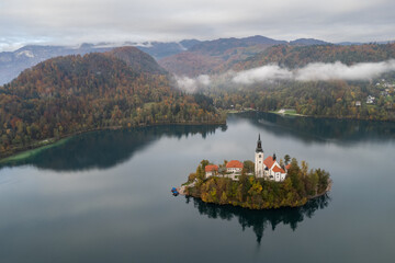 Lake bled island with assumption of mary pilgrimage church reflecting on the water during autumn season