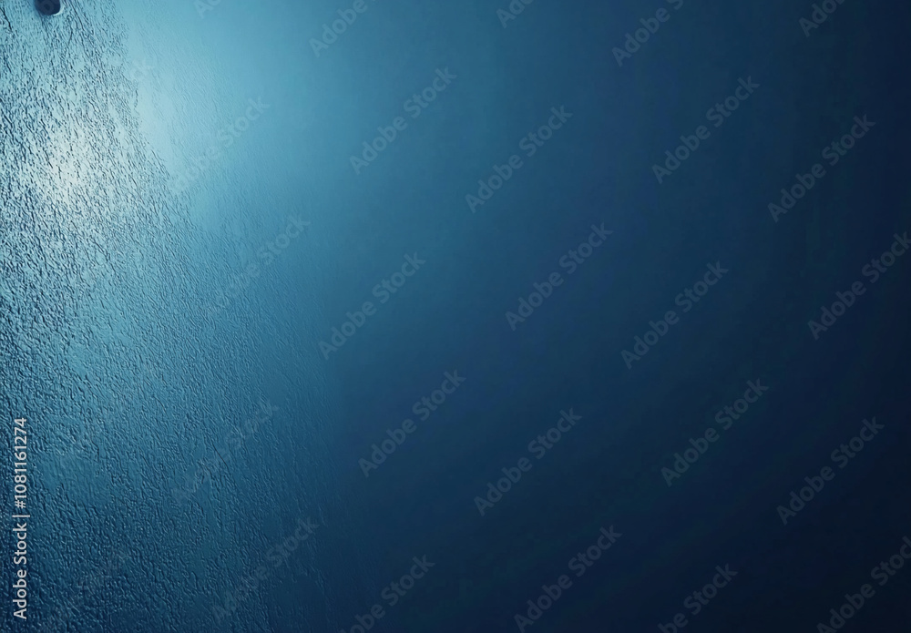 Poster A textured blue wall with a light source shining from the top left, creating a soft glow. The wall is a solid dark blue with light reflecting off of the texture