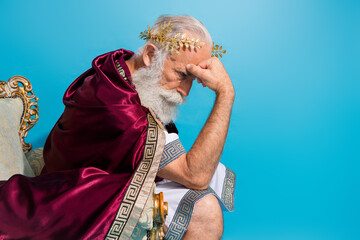 Profile photo of theater actor toga costume sit throne think empty space isolated on blue color background