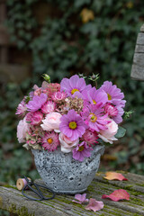 Blumen-Arrangement mit pink Schmuckkörbchen (Cosmea), strohblumen, Rosen, Herbstanemone und...