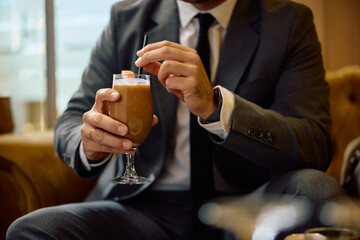 Close up of businessman drinking protein shake.
