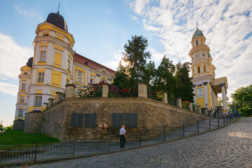 Naklejka premium uzhhorod, ukraine - 11 jun 2017: greek catholic cathedral in morning light. historic architecture. pentecost summer holiday. people gathering for celebration. amazing place