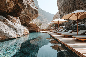 Fototapeta na wymiar A luxury resort pool surrounded by towering sandstone cliffs, minimalist wooden deck with beige umbrellas.