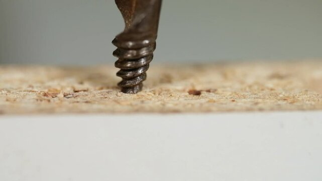 Making a hole in chipboard using a hand countersink.
