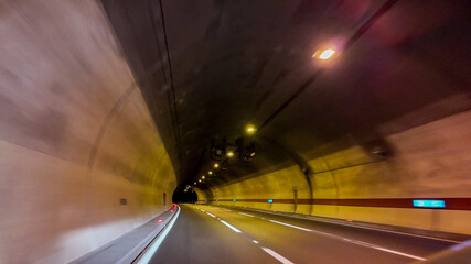 A well-lit highway tunnel stretches into the distance, symbolizing journey and exploration, ideal for travel and infrastructure themes