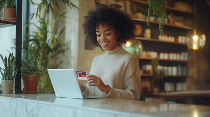 Smiling woman using credit card for online shopping in stylish café setting