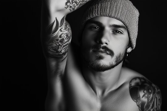 A man with tattoos and a beard is wearing a beanie