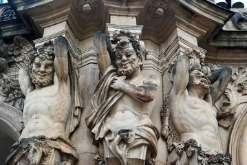 Sculptures of evil, exiled, damned people on the wall of a building in Dresden, Germany. Photo of...