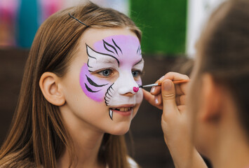 Professional make-up artist, artist paints face painting with watercolors, make-up for a happy...