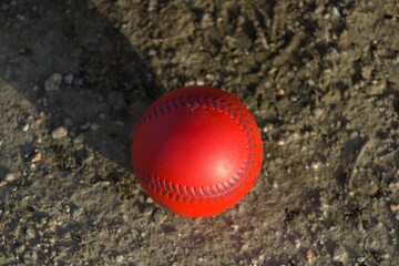 red plastic baseball toy with blue stitches 