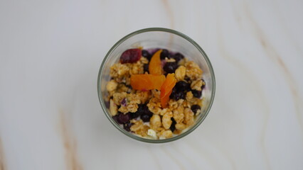Yogurt with granola, forest fruits and dried apricots