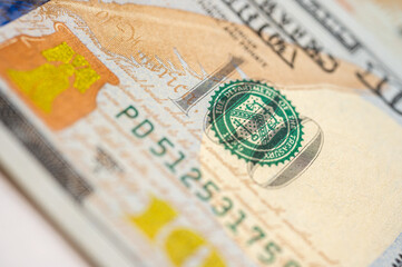 Close-up view of a 100 dollar bill with intricate details, security features and vibrant colors....