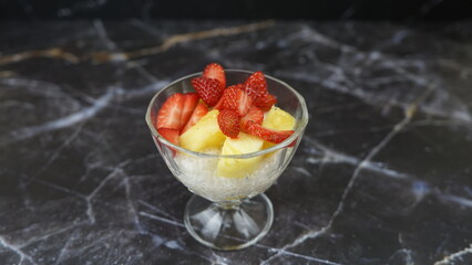 Dessert of tapioca balls with pineapple and mango in an ice cream cup