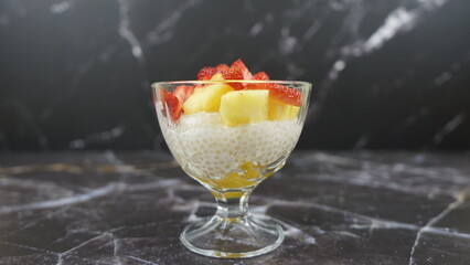 Dessert of tapioca balls with pineapple and mango in an ice cream cup