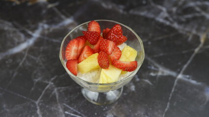 Dessert of tapioca balls with pineapple and mango in an ice cream cup