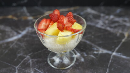 Dessert of tapioca balls with pineapple and mango in an ice cream cup