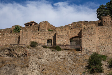 Scenic view of ancient ruins of Malaga Roman Theater (El Teatro Romano, I century BC) with historic Roman semi-circular seating at foot of famous Alcazaba fortress. Malaga, Andalusia, Spain.