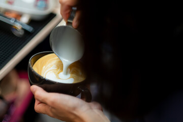 closeup hand doing hot latte art coffee