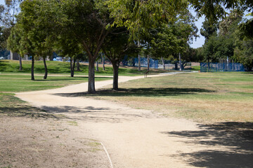 winding dirt path for walking near trees in the park