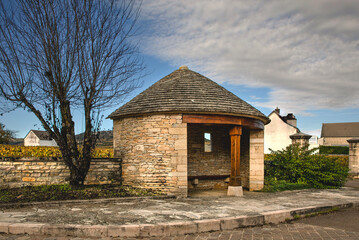 Traditional round house made of stone being used as a seating area and bus shelter