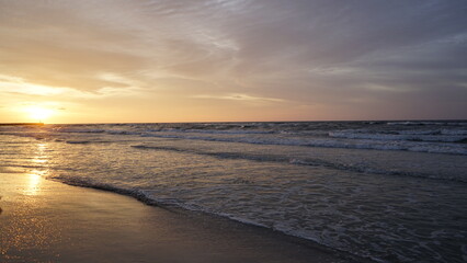 Obraz premium Sunset on the beach by the sea