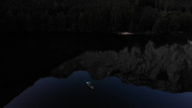 The fisherman in the boat on the green lake