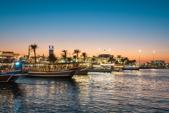 Night view of the Qatari Emiri Parliament building in the background with boats in the sea