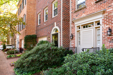 Modern brick townhouse frontage with brick sidewalk and flowerbeds at the entrance.