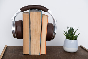 stack of books with headphones, learning foreign languages using audiobooks, multimedia learning, developing reading and listening skills, technology in education