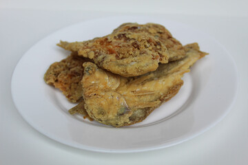 Fried fish. Preserved fish by salting method, half cut, flour coated, called Gereh or Ikan Asin in Indonesia. Isolated on white background