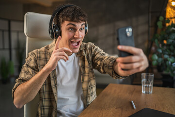 Young smile man with headphones have video call on mobile phone