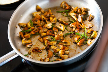 Delicious champignon mushrooms with asparagus fried in frying pan