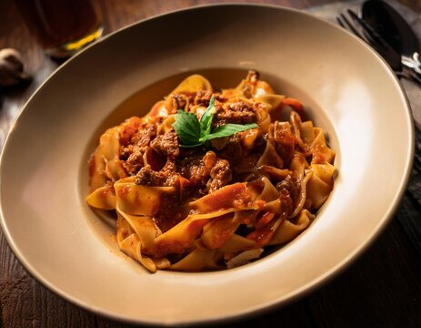 Pappardelle Al Cinghiale Wild Boar Ragu Pasta with Rich Tomato Sauce, Captured in Dramatic Low Lighting for a Rustic, Authentic Italian Dining Experience