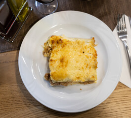 Appetizing baked stuffed meat cannelloni with cheese served on plate..