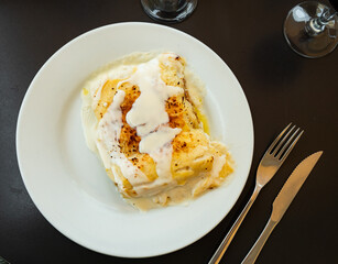 Traditional Italian Cannelloni stuffed with minced meat baked in bechamel sauce with grated cheese