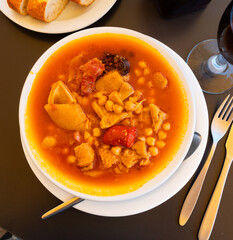 Spanish stew of chickpeas, chorizo sausages with tomatoes and pork meat with garlic. Meat with beans according to a traditional Catalan recipe