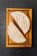 Grilled tortilla wraps with fresh veggies on a wooden board for a quick and tasty meal