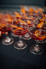 table full of whiskey cocktails with cinnamon and orange peel garnish