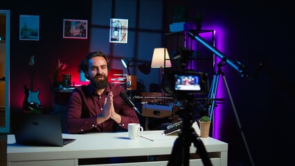 Content creator entering home studio, doing cool hand gesturing towards camera during live broadcast on online streaming platforms. Entertainer pointing fingers, captivating audience, camera B