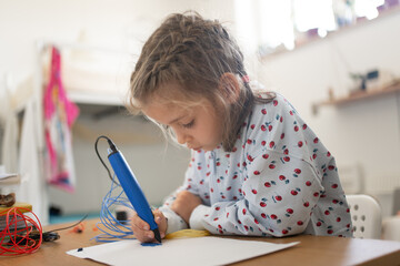 3D pen cute girl creating plastic 3D model, drawing. Smart child drawing with pen on paper at...