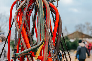 Saws for pruning a Christmas tree at a spruce nursery.Colorful saws set on blurred christmas fair....