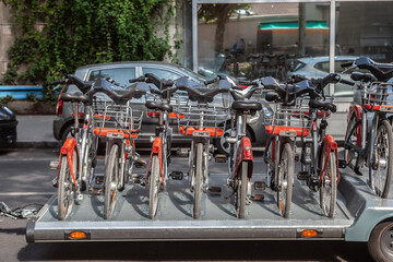 Self-rental bicycles loaded onto a trailer rack on the streets of Lyon, France, showcasing urban mobility and eco-friendly transportation options in the city with bicycle sharing options.