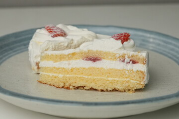 Two Japanese strawberry shortcakes on a stylish large plate on a white table